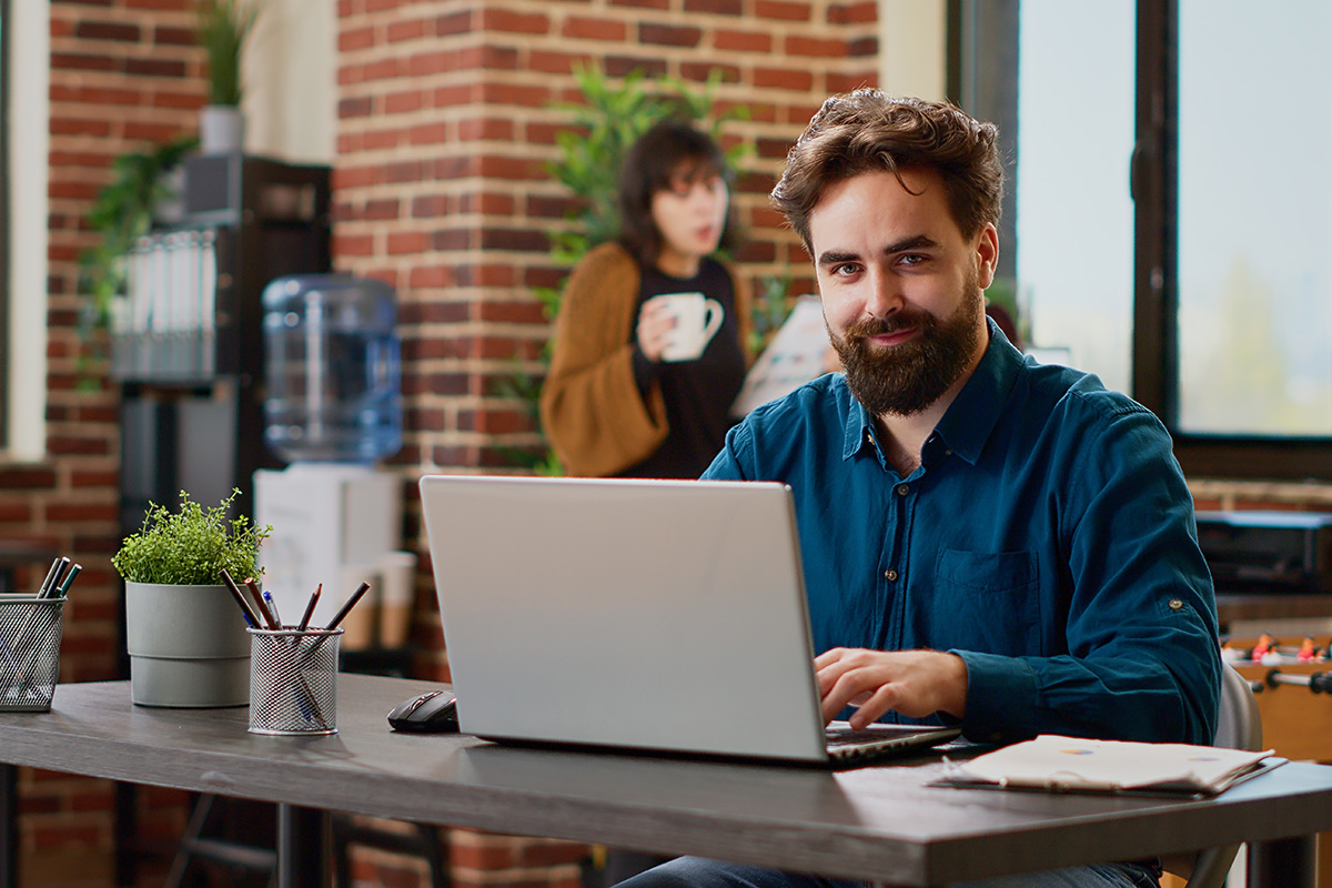 Man sitting at an office desk on a laptop