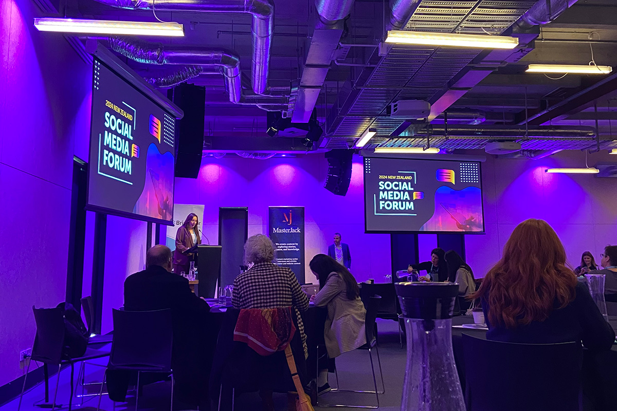 A woman presenting on stage at a conference