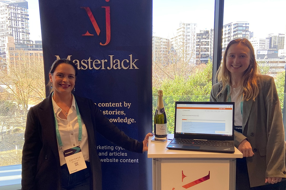 Lisa and Rachel from the MasterJack team at a conference, standing in front of a MasterJack display