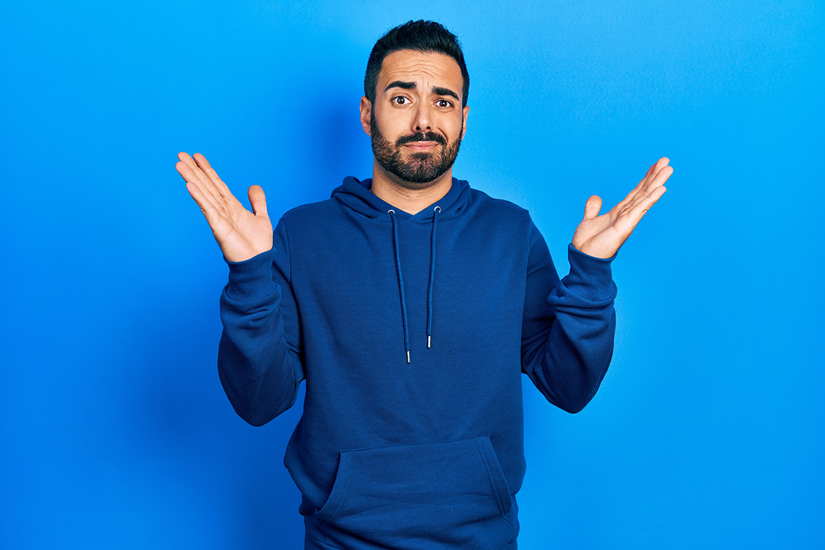 man in blue hoodie shrugging shoulders