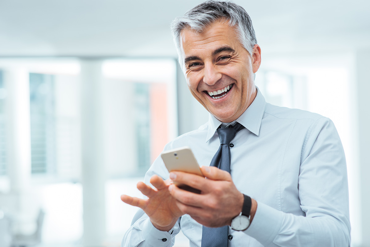 happy businessman scrolling on smartphone