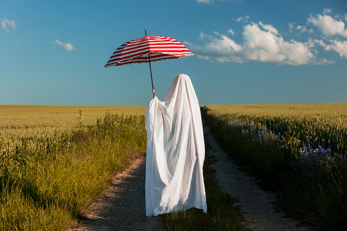 ghost in field holding an umbrella